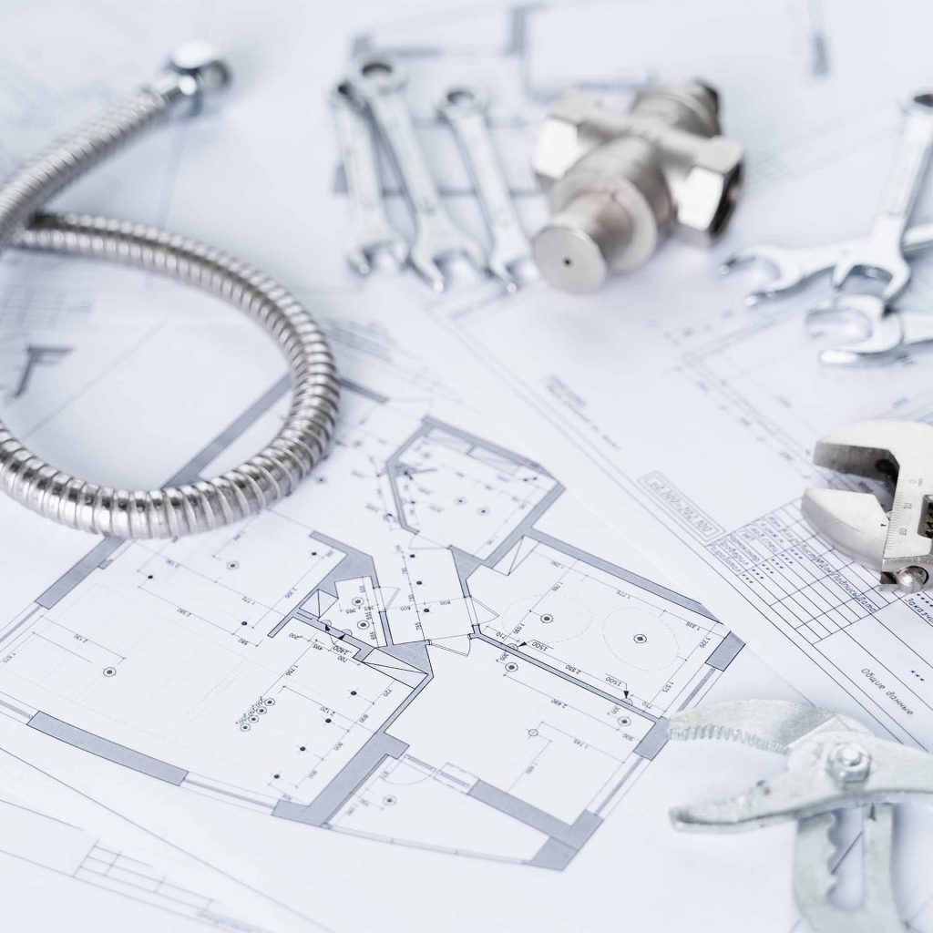 Tools laying on top of a plumbing design blueprint.